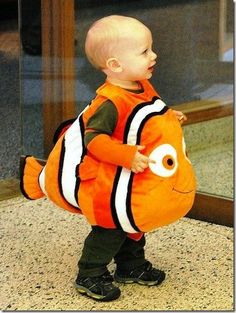 a small child in an orange fish costume