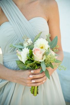 a woman in a white dress holding a bouquet