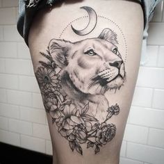 a woman's thigh with a lion and flowers on it