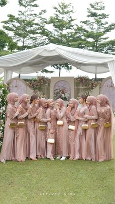 a group of women standing next to each other in front of a white gazebo