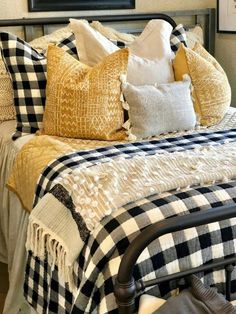 a bed topped with lots of pillows next to a painting on the wall above it