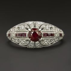 Why we love it:This diamond and ruby ring is beautifully crafted with a geometric Art Deco style design and encrusted with glittering diamonds and rich red rubies!Highlights:- 0.35ct natural ruby center with gorgeous, well saturated color- Calibre cut natural rubies with bright red color- 0.13ct of high quality diamond accents- Unique and elegant vintage style design- Classic 14k white gold settingDimensions:9.0mm across (north-south) and 4.5mm from the finger to the top of the ring Christmas Presents For Moms, Diamond Glitter, Gold Art Deco, Diamond Cocktail Rings, Ruby Jewelry, Ruby Diamond, Gold Art, Natural Ruby, Ruby Ring