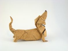 an origami dachshund dog is standing on its hind legs and tail