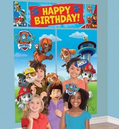 two girls standing in front of a paw patrol birthday banner