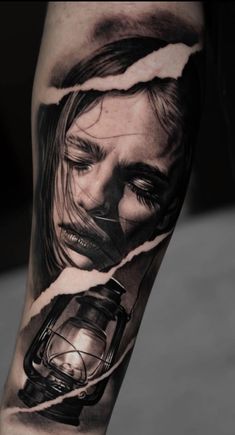 a man's arm with a black and white tattoo on it, depicting a woman holding