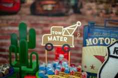 an assortment of toy cars and other items on display in front of a brick wall