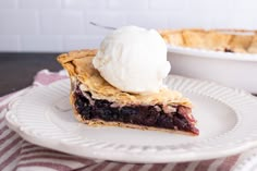 a piece of pie on a plate with ice cream in the middle and a bowl behind it