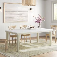 a white dining table and chairs in a room