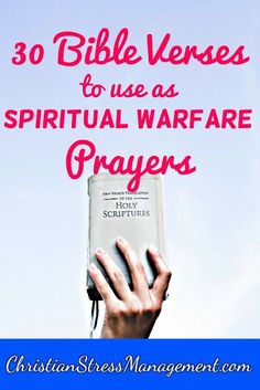 hands holding up a bible with the words 30 bible verses to use as spiritual warfare