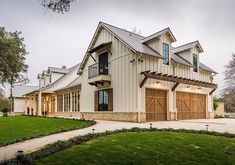 a large white house with two garages on the front and one story attached to it