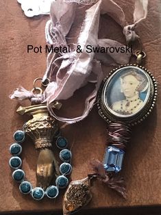 an assortment of jewelry is laying on the floor next to a piece of cloth and ribbon