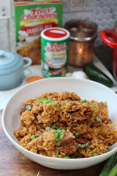 a white bowl filled with rice and peas on top of a wooden table next to other ingredients