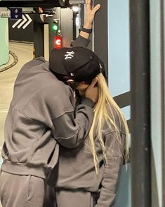 a man and woman kissing while standing next to each other