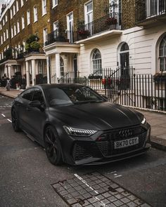 a black sports car parked on the side of the road in front of some buildings