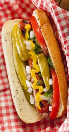 a hot dog with mustard, ketchup and peppers