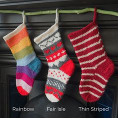 three knitted socks hanging from a wire next to a fireplace with the words rainbow, fair isle, thin striped