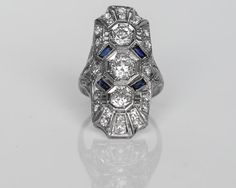 Circa 1930 - Platinum Art Deco Shield Ring with Old European Cut Diamonds & Sapphires - 1.20cttw - VEG#396 Fine Jewelry Platinum Multi-stone Diamond Ring, Platinum Multi-stone Diamond Ring Fine Jewelry, Multi-stone Platinum Diamond Ring In Fine Jewelry Style, Fine Jewelry Multi-stone Platinum Diamond Ring, Platinum Multi-stone Diamond Ring, Art Deco Multi-stone Platinum Diamond Ring, Art Deco Multi-stone Diamond Ring, Classic Multi-stone Platinum Diamond Ring, Art Deco Platinum Multi-stone Rings