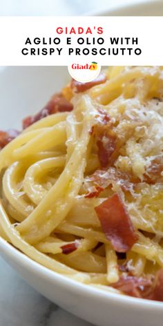 a white bowl filled with pasta covered in sauce and cheese on top of a marble table