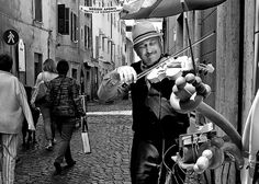 a man is playing the violin in an alley