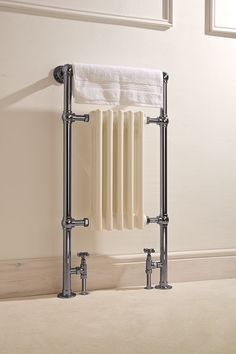 an old fashioned radiator in a bathroom with white towels hanging on the wall