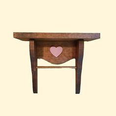 a wooden table with a heart cut out on the top and one drawer below it