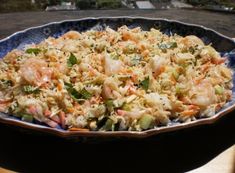 a blue bowl filled with rice and shrimp