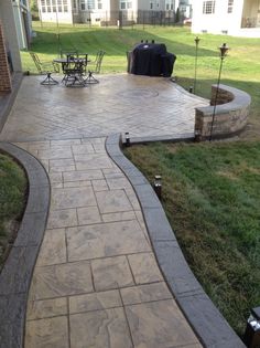 an outdoor patio with brick pavers and stone walkway leading up to the back yard