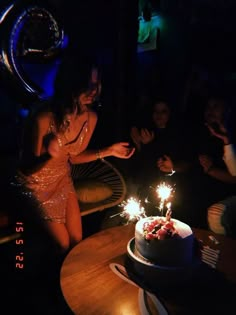 a woman blowing out the candles on her birthday cake