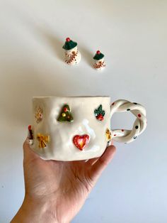 a hand holding a coffee cup with christmas decorations on it