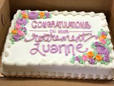 a cake in a box that says congratulations on the front with flowers and vines around it