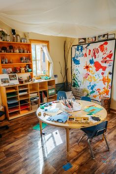 a room with wooden floors and lots of clutter on the table in front of it