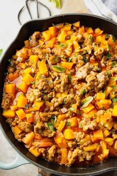 a skillet filled with buttered sausage and squash