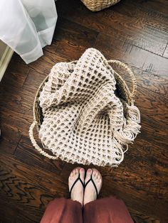 a woman's feet and handbag on the floor next to her purse, which has been crocheted