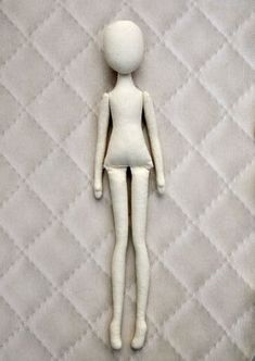 a white doll sitting on top of a bed