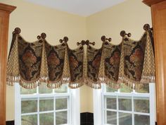 a kitchen window with an ornate valance and matching curtains