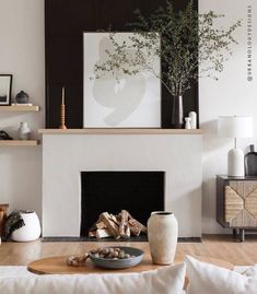 a living room filled with furniture and a fire place in front of a white fireplace