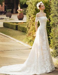 a woman in a wedding dress is standing outside