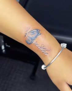 a woman's arm with a butterfly tattoo on it and the word believe written in cursive writing