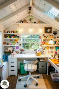 a home office with lots of clutter on the desk and shelves in the ceiling