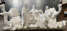 a group of white statues sitting on top of a wooden table