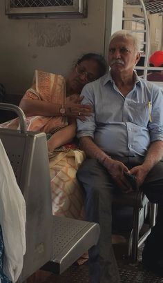 an older man sitting next to a woman in a hospital bed