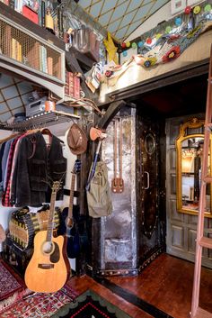 a room filled with lots of different types of hats and guitars hanging from the ceiling