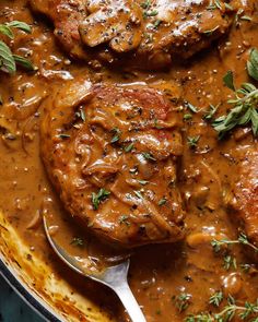 meat with gravy and herbs in a skillet