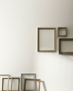 four empty frames on the wall with one leaning up against it's back side