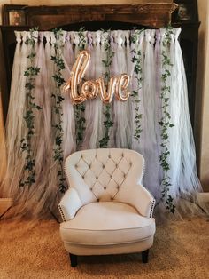 a white chair sitting in front of a love sign