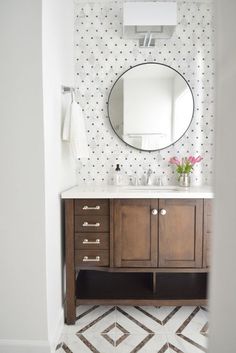 a bathroom with a sink, mirror and tiled floor