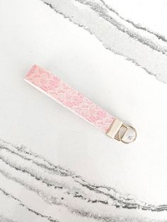 a pink keychain sitting on top of a marble counter