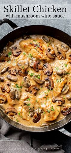 skillet chicken with mushrooms and wine sauce in a black pan on a gray background