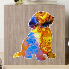 a dog is sitting on top of a cabinet with colorful paint splattered on it