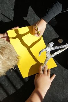 two children are doing crafts with paper and scissors